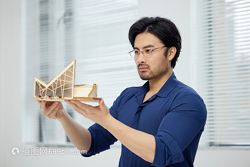 建筑設計師手拿建筑模型研究